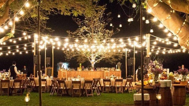 stunning event lighting with festoon lights strung above dinner tables at night
