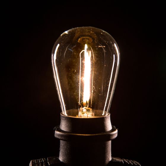 product shot of an illuminated light bulb on black background