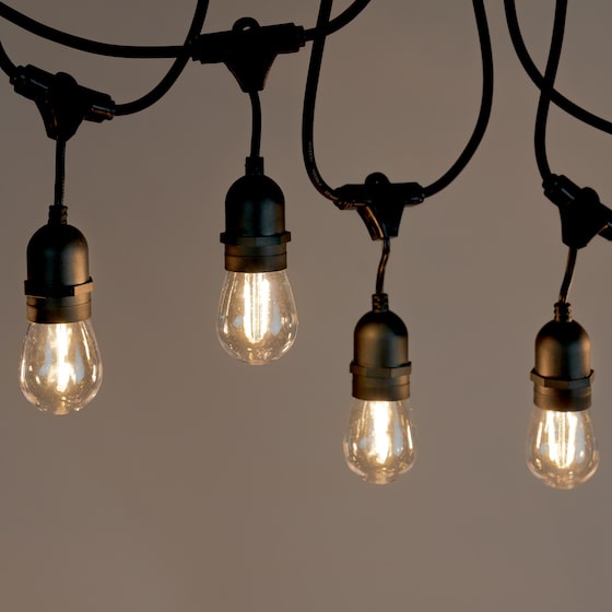Hanging festoon lights on grey background in black